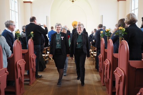 Billedet viser personer, der går på en række i en kirke.