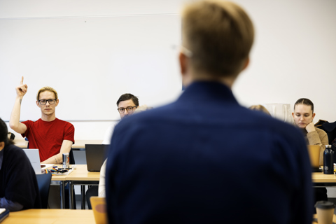 Billedet viser et klasseværelse med studerende og en underviser.